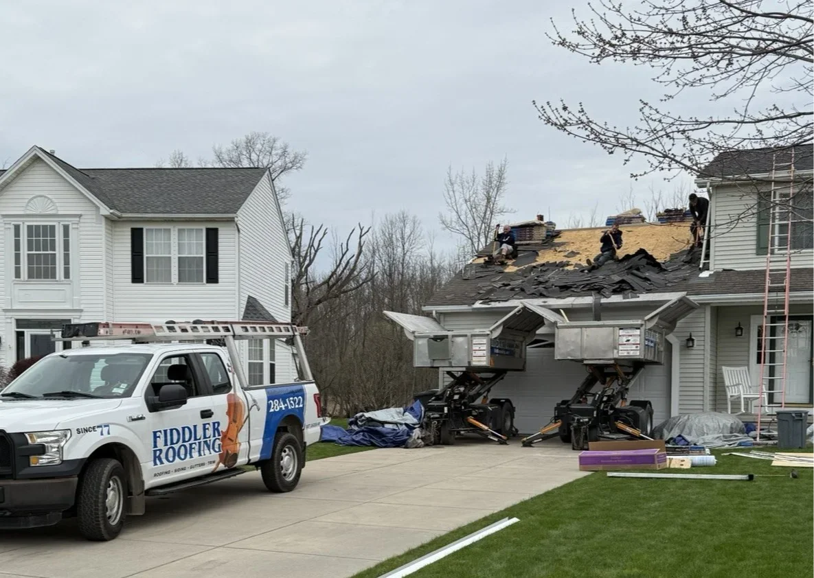 Modern suburban neighborhood rooftops with various roofing materials and workers performing roof inspections, illustrating roofing myths and their impact.