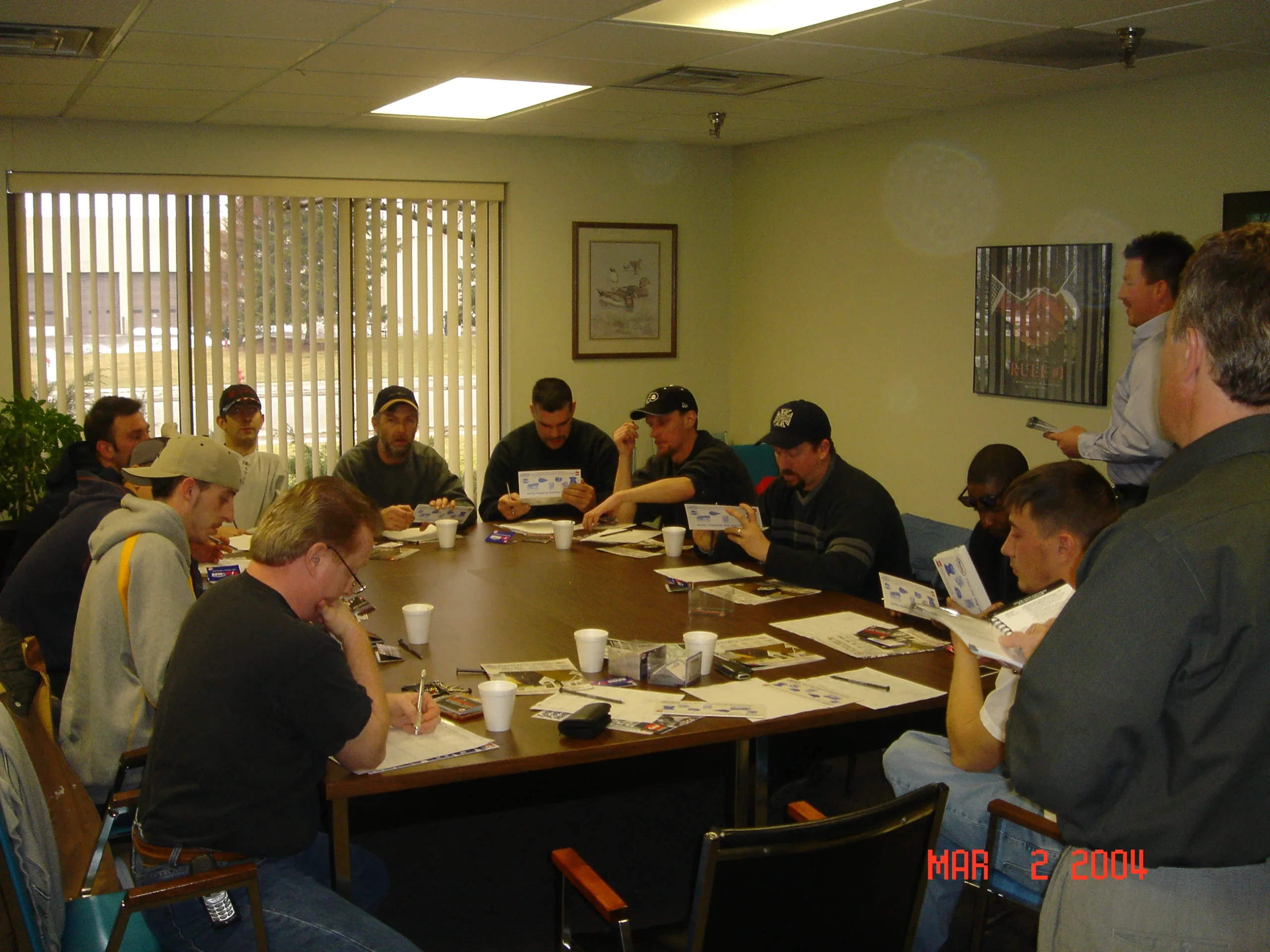 Fiddler Roofing pros undergoing rigorous 20-part cleanup training—roofing crew gathered attentively around an instructor demonstrating magnet nail sweeps and immaculate debris removal techniques to uphold the company's spotless-job-site standard.