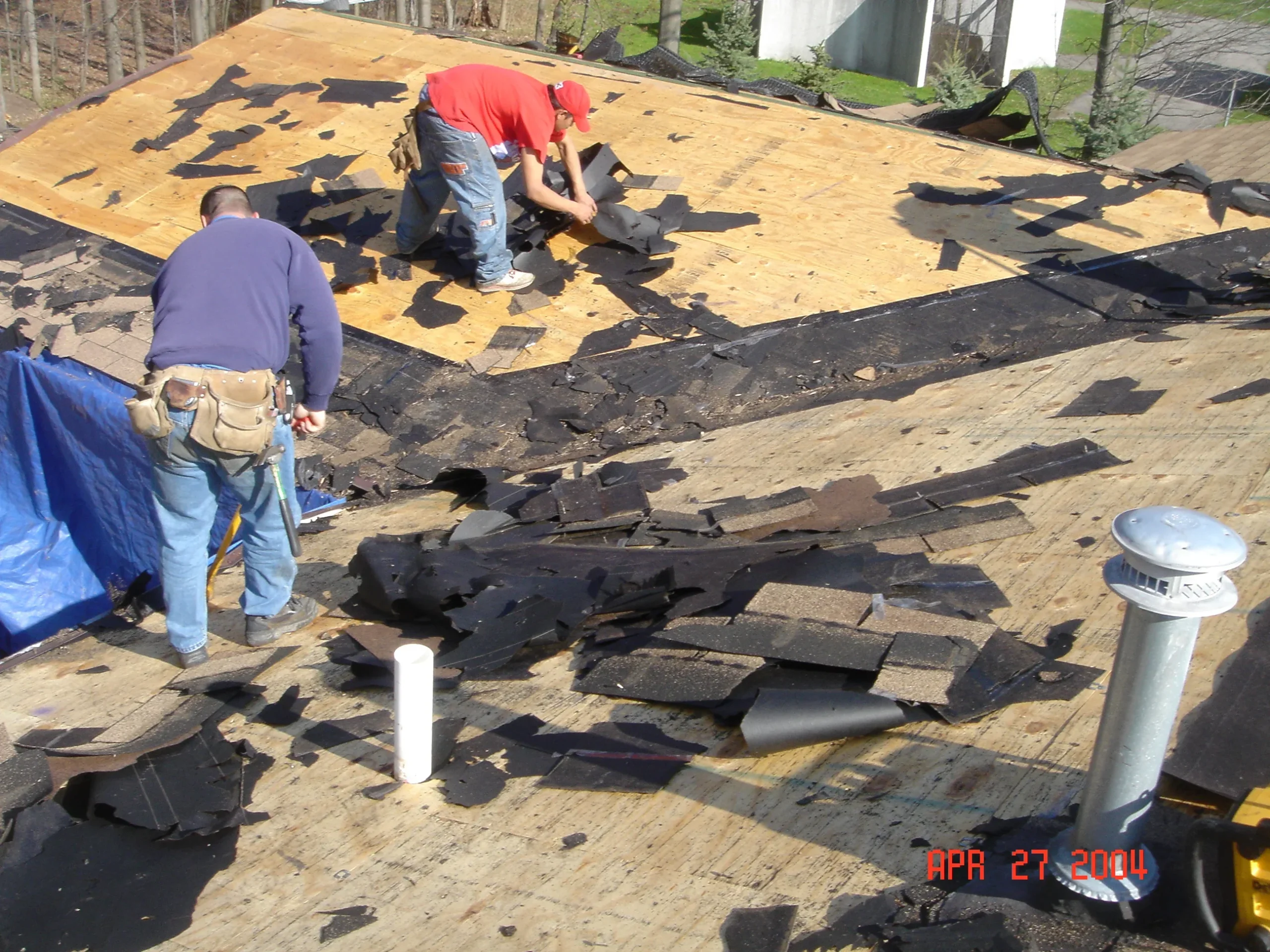 Content homeowner observing clean, flowing gutters along a residential roof, highlighting the impact of gutters on roof health.