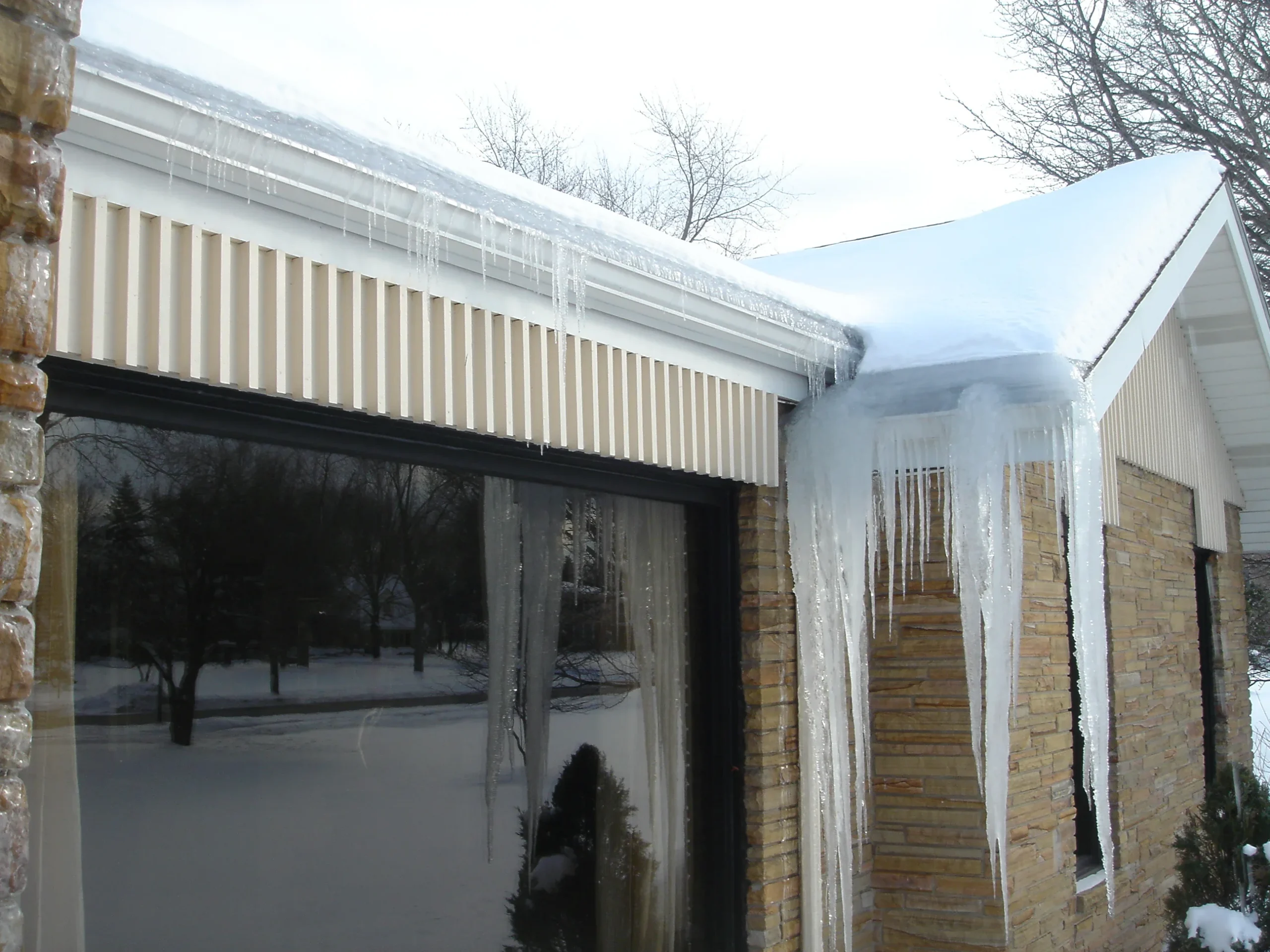 Winter roof maintenance—homeowner in winter clothing inspecting snow and icicles along roof edge, roof care checklist, photorealistic