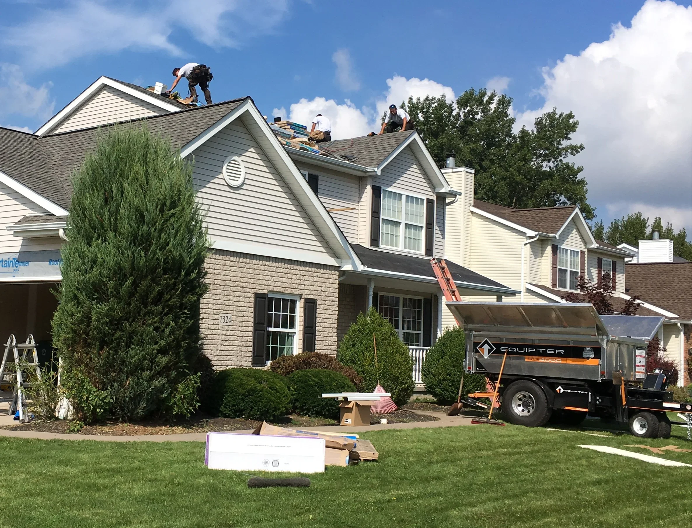 Professional roofers in Buffalo installing modern roof—tool belts, safety harnesses, confidence and teamwork. Roofing solutions Western New York can depend on.