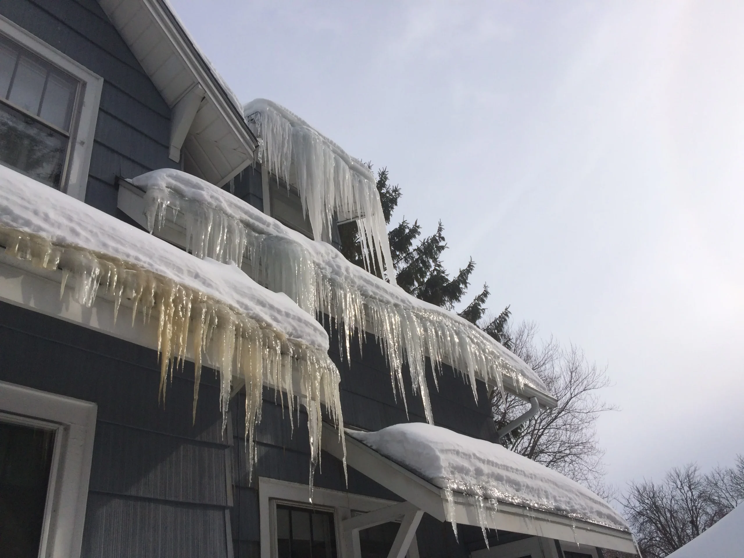 Comparison of harmless small icicles and large dangerous icicles on house gutter.