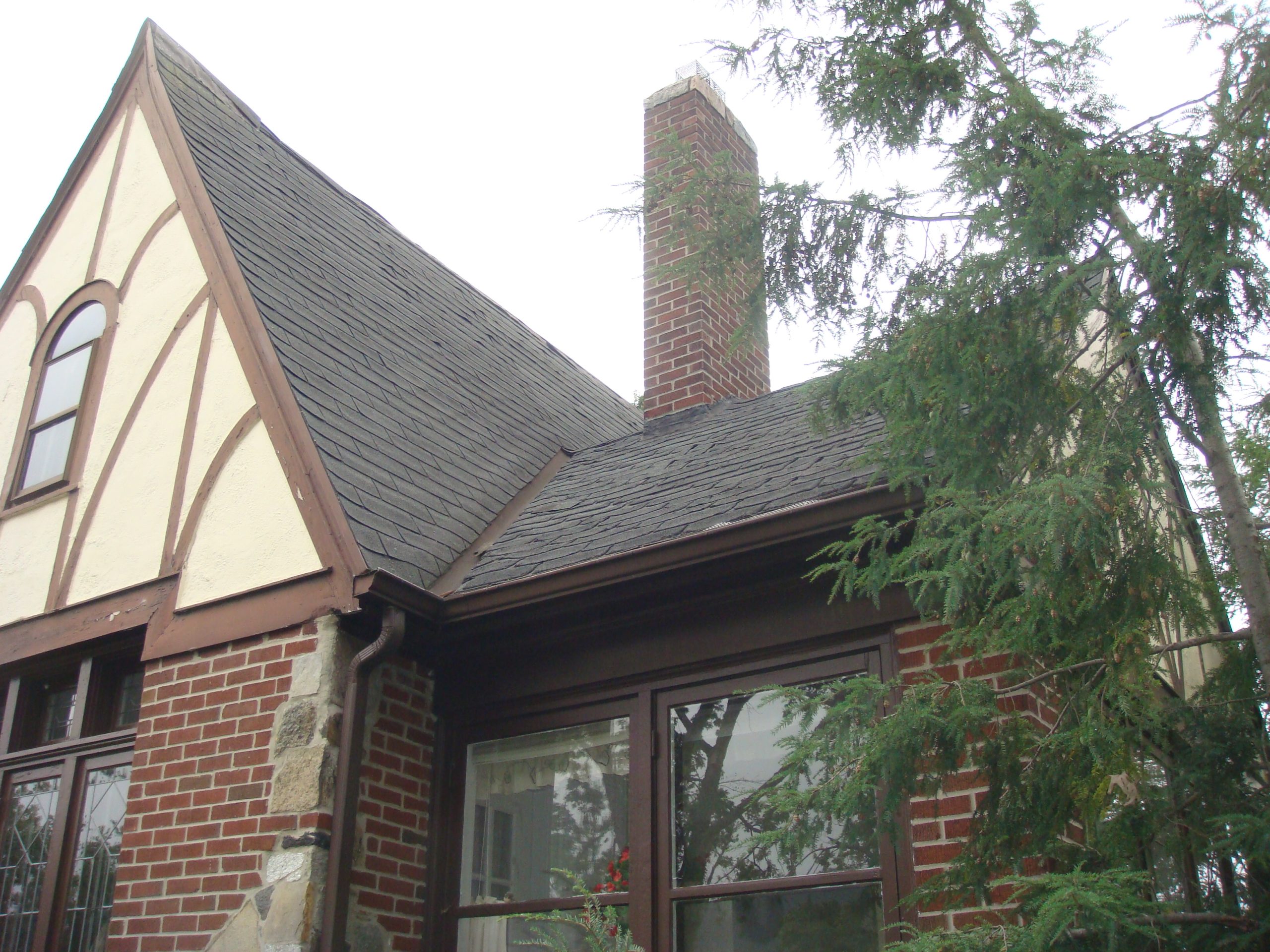 roof replacement cost niagara falls - Homeowner with roofer reviewing shingle condition and replacement options